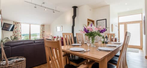 The dining area of Early Mist cottage with table and chairs where families ca get together and enjoy the woodburner